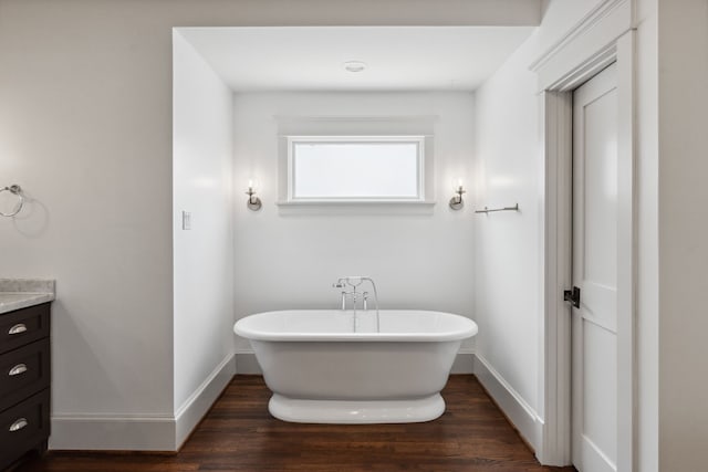 1409 Tulane St, Houston, TX 77008 - full bathroom featuring vanity, a soaking tub, wood finished floors, and baseboards