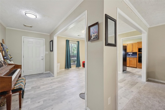 517 Hillebrandt, Beaumont, TX 77705 - foyer featuring a textured ceiling, light wood-style floors, crown molding, and baseboards