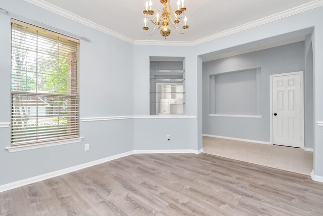 19 Long Springs Pl, The Woodlands, TX 77382 - empty room with a chandelier, wood finished floors, crown molding, baseboards, and built in shelves