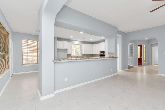 19 Long Springs Pl, The Woodlands, TX 77382 - kitchen with arched walkways, ceiling fan, light marble finish floors, backsplash, and recessed lighting