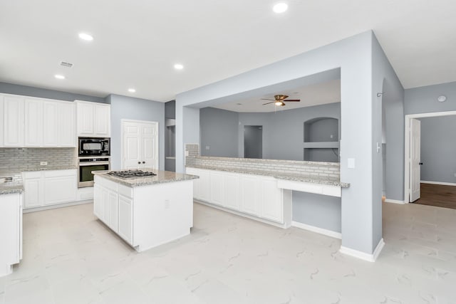 19 Long Springs Pl, The Woodlands, TX 77382 - kitchen with appliances with stainless steel finishes, decorative backsplash, a ceiling fan, a center island, and recessed lighting