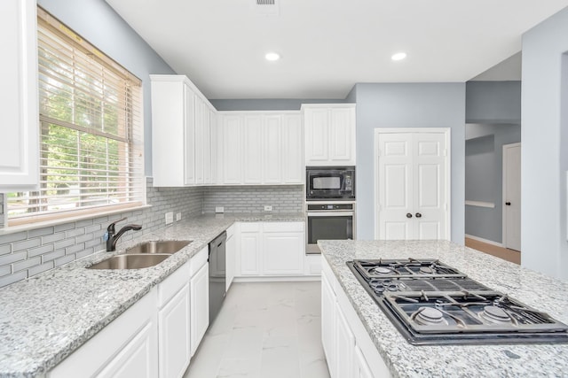 19 Long Springs Pl, The Woodlands, TX 77382 - kitchen featuring black appliances, a sink, light marble finish floors, decorative backsplash, and recessed lighting