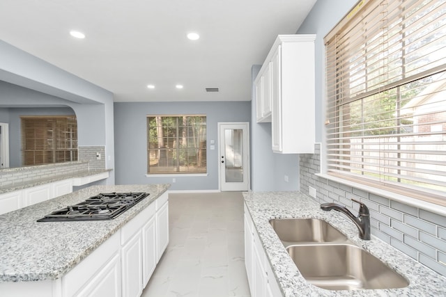 19 Long Springs Pl, The Woodlands, TX 77382 - kitchen with a sink, backsplash, recessed lighting, black gas stovetop, and light stone countertops