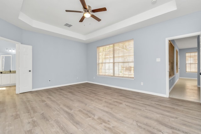 19 Long Springs Pl, The Woodlands, TX 77382 - spare room featuring a raised ceiling, ceiling fan, baseboards, and light wood finished floors