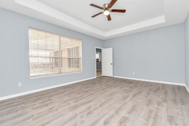 19 Long Springs Pl, The Woodlands, TX 77382 - unfurnished room with a tray ceiling, ceiling fan, wood finished floors, and baseboards