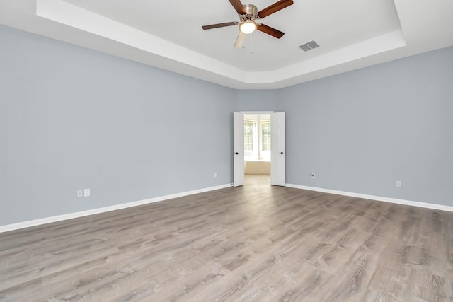19 Long Springs Pl, The Woodlands, TX 77382 - empty room with a raised ceiling, ceiling fan, baseboards, and wood finished floors