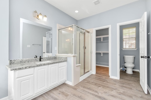 19 Long Springs Pl, The Woodlands, TX 77382 - bathroom featuring a stall shower, vanity, toilet, and wood finished floors