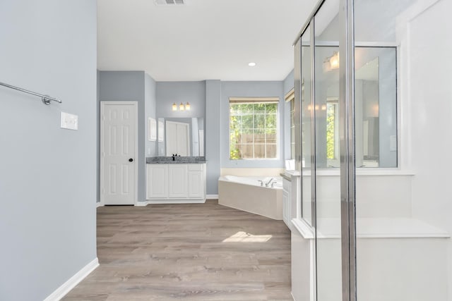 19 Long Springs Pl, The Woodlands, TX 77382 - bathroom with vanity, a garden tub, wood finished floors, a shower stall, and baseboards
