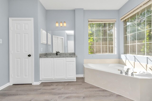 19 Long Springs Pl, The Woodlands, TX 77382 - bathroom featuring a bath, vanity, wood finished floors, and baseboards