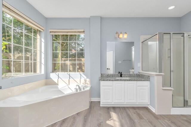 19 Long Springs Pl, The Woodlands, TX 77382 - full bath featuring a stall shower, vanity, a garden tub, wood finished floors, and baseboards
