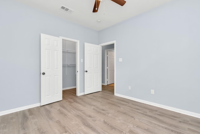 19 Long Springs Pl, The Woodlands, TX 77382 - unfurnished bedroom featuring light wood-style flooring, baseboards, a spacious closet, and a closet