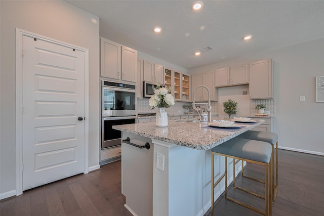 2923 Laurel Mill Way, Houston, TX 77080 - kitchen with a sink, appliances with stainless steel finishes, tasteful backsplash, recessed lighting, and glass insert cabinets