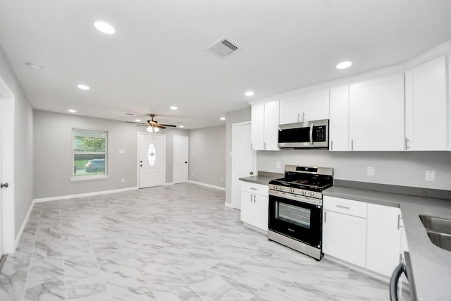 3030 Dacca Dr, Houston, TX 77051 - kitchen with appliances with stainless steel finishes, light marble finish flooring, recessed lighting, white cabinetry, and a ceiling fan