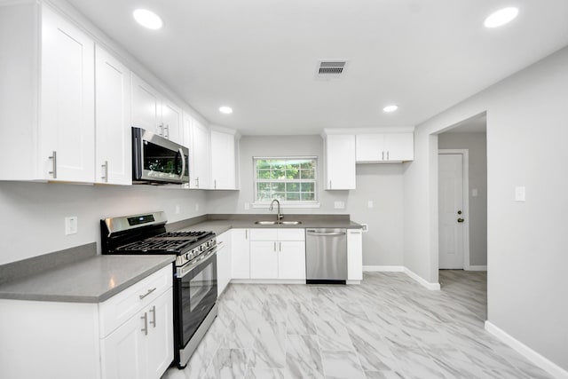 3030 Dacca Dr, Houston, TX 77051 - kitchen with appliances with stainless steel finishes, a sink, recessed lighting, white cabinets, and baseboards