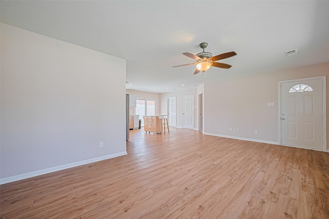 115 N 12th St, Highlands, TX 77562 - unfurnished living room featuring light wood-style floors, a ceiling fan, and baseboards