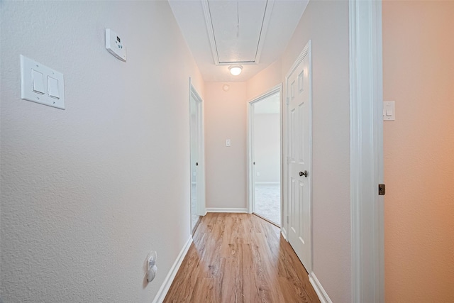 115 N 12th St, Highlands, TX 77562 - corridor with attic access, light wood-style floors, and baseboards
