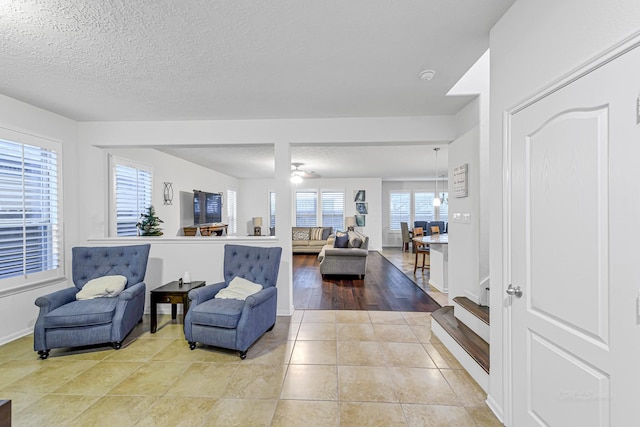 28614 Cabrera Hill Ln, Katy, TX 77494 - living room featuring light tile patterned floors, a textured ceiling, and baseboards