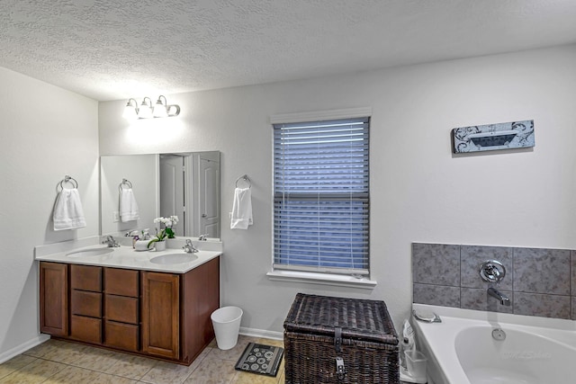 28614 Cabrera Hill Ln, Katy, TX 77494 - bathroom with double vanity, a bath, a textured ceiling, baseboards, and tile patterned floors