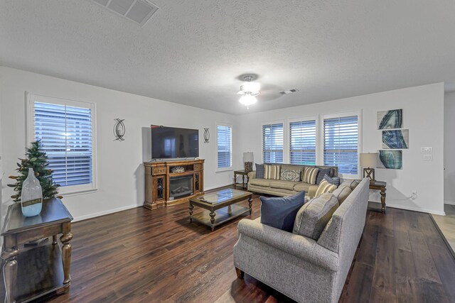 28614 Cabrera Hill Ln, Katy, TX 77494 - living area with wood finished floors, a textured ceiling, a glass covered fireplace, and baseboards