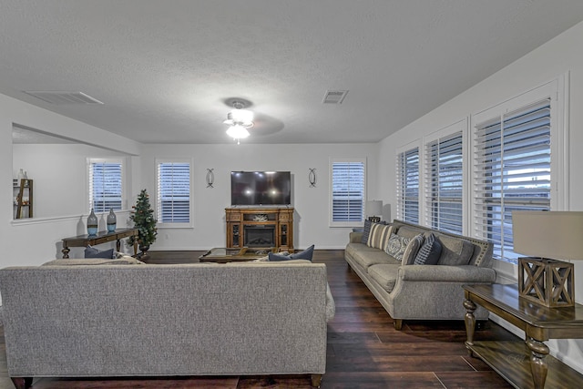 28614 Cabrera Hill Ln, Katy, TX 77494 - living room with dark wood-style floors, a textured ceiling, ceiling fan, and a fireplace