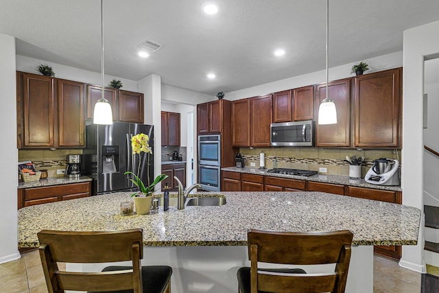 28614 Cabrera Hill Ln, Katy, TX 77494 - kitchen featuring stainless steel appliances, a sink, tasteful backsplash, a kitchen breakfast bar, and pendant lighting