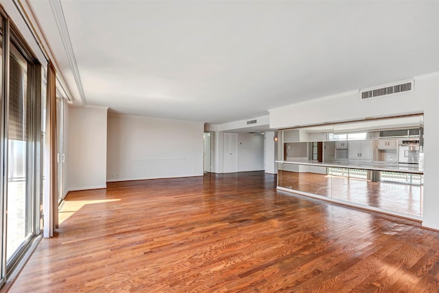 2016 Main St Unit 620, Houston, TX 77002 - unfurnished living room with plenty of natural light, wood finished floors, ornamental molding, and baseboards