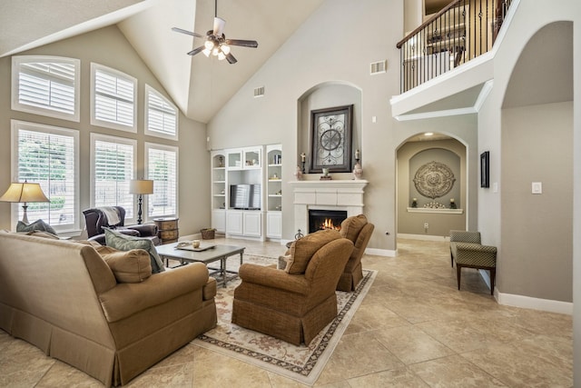 4611 Kings Landing Ln, Katy, TX 77494 - living room with ceiling fan, a warm lit fireplace, high vaulted ceiling, baseboards, and arched walkways
