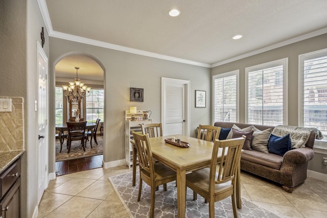 4611 Kings Landing Ln, Katy, TX 77494 - dining area featuring a chandelier, healthy amount of natural light, crown molding, arched walkways, and baseboards