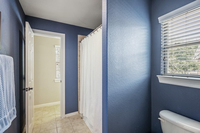 4611 Kings Landing Ln, Katy, TX 77494 - bathroom featuring toilet, tile patterned flooring, a textured wall, a shower with curtain, and baseboards