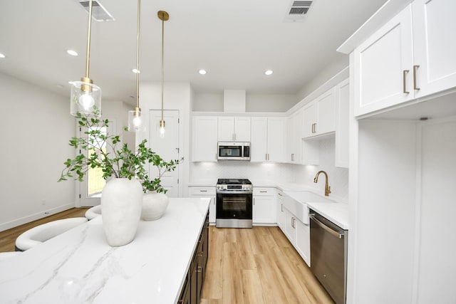 4602 Bristol St, Houston, TX 77009 - kitchen with stainless steel appliances, light wood-style flooring, a sink, decorative backsplash, and recessed lighting