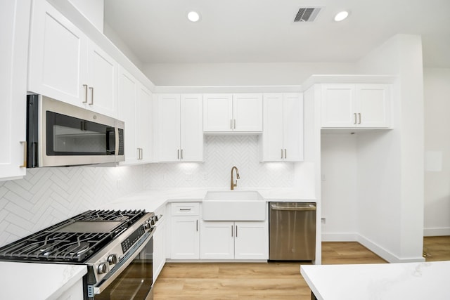 4602 Bristol St, Houston, TX 77009 - kitchen with stainless steel appliances, a sink, white cabinetry, and recessed lighting