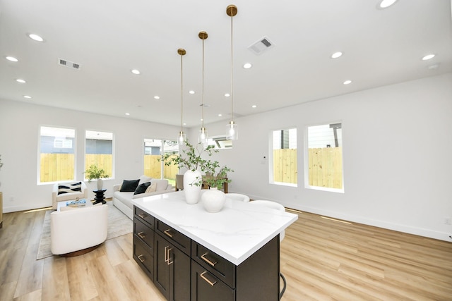 4602 Bristol St, Houston, TX 77009 - kitchen featuring open floor plan, light wood-style floors, a kitchen island, recessed lighting, and decorative light fixtures