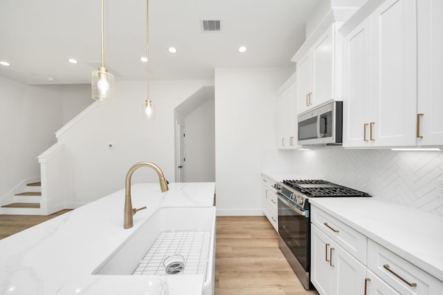 103 Frawley St, Houston, TX 77009 - kitchen with stainless steel appliances, a sink, tasteful backsplash, light wood-style floors, and recessed lighting