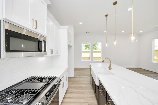 103 Frawley St, Houston, TX 77009 - kitchen featuring appliances with stainless steel finishes, a sink, light wood finished floors, backsplash, and recessed lighting