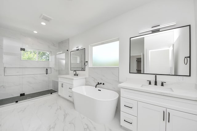 103 Frawley St, Houston, TX 77009 - bathroom with marble finish flooring, a marble finish shower, plenty of natural light, two vanities, and recessed lighting