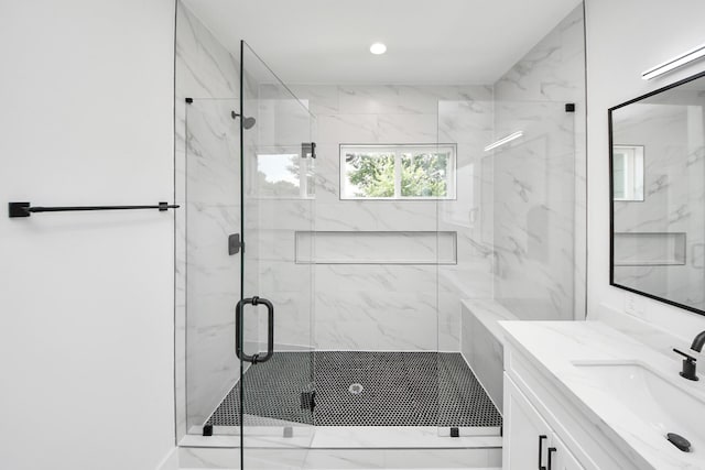 103 Frawley St, Houston, TX 77009 - bathroom featuring a marble finish shower, vanity, marble look tiles, and recessed lighting