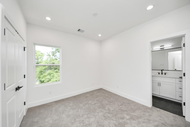 103 Frawley St, Houston, TX 77009 - unfurnished bedroom featuring dark carpet, a sink, recessed lighting, baseboards, and ensuite bathroom