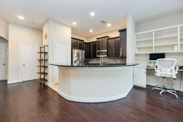 5142 Oasis Park, Houston, TX 77021 - kitchen with appliances with stainless steel finishes, dark stone counters, dark wood-type flooring, dark brown cabinets, and a desk