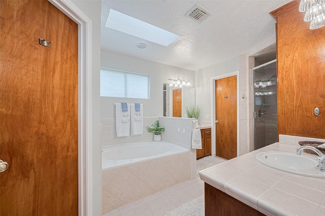 334 Swords Bnd, Stafford, TX 77477 - full bathroom with a skylight, a garden tub, tile patterned floors, vanity, and a textured ceiling
