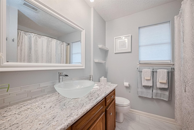 334 Swords Bnd, Stafford, TX 77477 - bathroom with vanity, toilet, a textured ceiling, marble look tile flooring, and baseboards