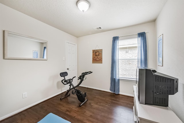 4223 Leafy Bough Ct, Humble, TX 77346 - workout area with dark wood-type flooring, baseboards, and a textured ceiling