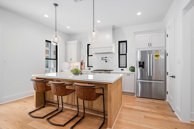 515 E 4th St, Houston, TX 77007 - kitchen with stainless steel refrigerator with ice dispenser, custom range hood, light countertops, light wood finished floors, and recessed lighting
