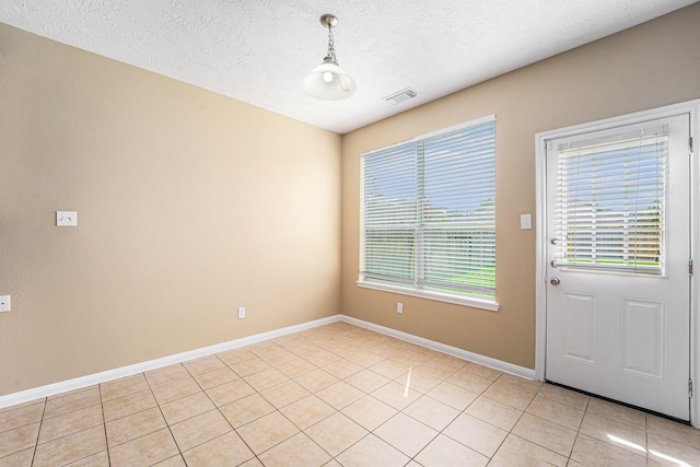 13707 Kingston River Ln, Houston, TX 77044 - unfurnished dining area featuring a textured ceiling, baseboards, and light tile patterned floors