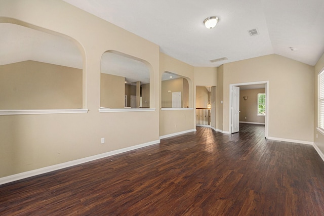 13707 Kingston River Ln, Houston, TX 77044 - unfurnished living room featuring vaulted ceiling, wood finished floors, baseboards, and arched walkways
