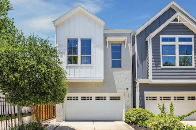 406 Welch St, Houston, TX 77006 - view of front of home with board and batten siding, an attached garage, and concrete driveway