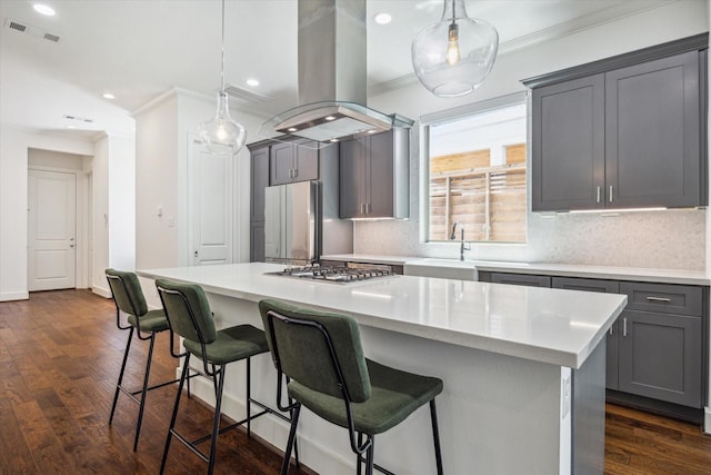 406 Welch St, Houston, TX 77006 - kitchen featuring ornamental molding, island range hood, gray cabinetry, stainless steel gas cooktop, and freestanding refrigerator