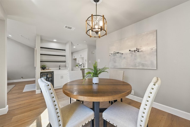 2829 Timmons Ln Unit 222, Houston, TX 77027 - dining space with wine cooler, a chandelier, baseboards, light wood-type flooring, and recessed lighting