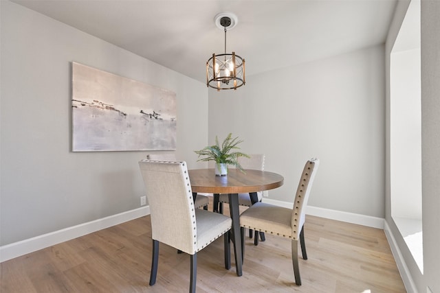 2829 Timmons Ln Unit 222, Houston, TX 77027 - dining area with a chandelier, light wood-style flooring, and baseboards