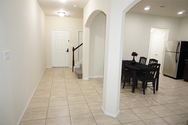 1608 Grable Cove Ln, Spring, TX 77379 - hall featuring light tile patterned flooring, stairway, arched walkways, and baseboards