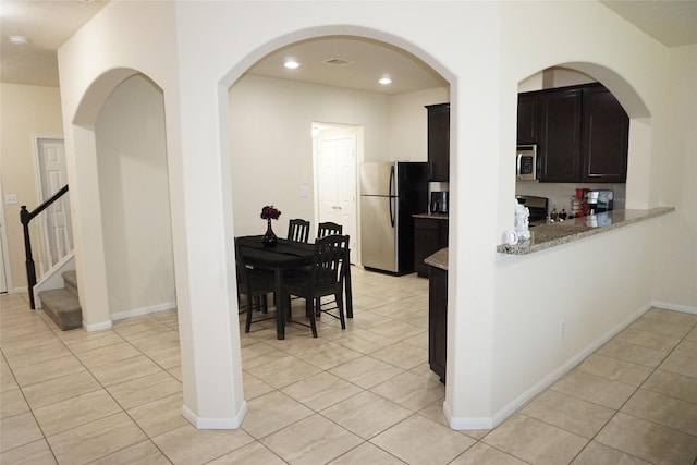 1608 Grable Cove Ln, Spring, TX 77379 - kitchen featuring stainless steel appliances, light tile patterned flooring, light stone countertops, baseboards, and recessed lighting